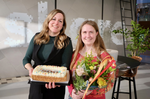 Twee dames van ITvitae met bloemen en een taart