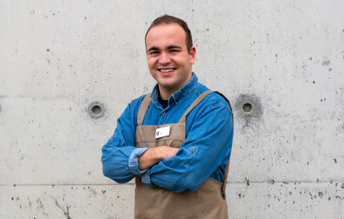 Tim de poseert voor een betonnen muur