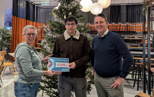 Jongen ontvangt cheque van vertegenwoordiger Driessen Foundation