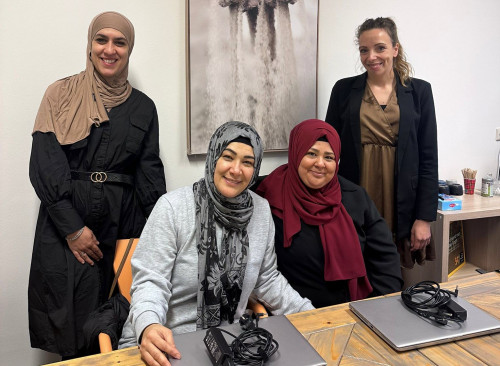 Twee vertegenwoordigers Driessen Foundation staan bij twee vrouwen die laptops hebben ontvangen